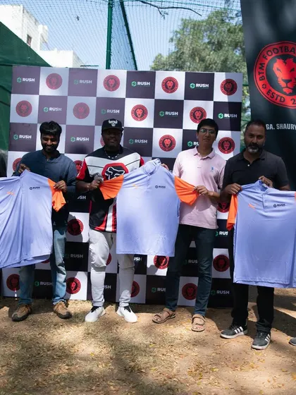 The management team proudly displays the new training kits for the upcoming season.