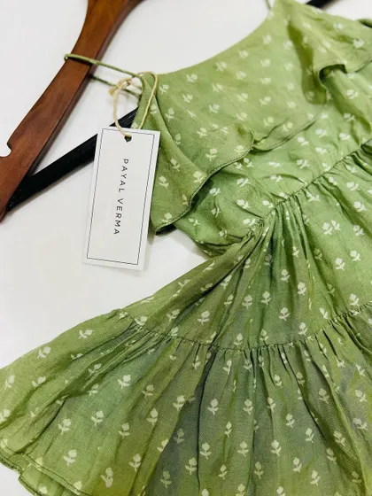 A detail shot showing the Payal Verma brand tag on our green cotton dress. We take pride in the quality and craftsmanship of every piece we create.