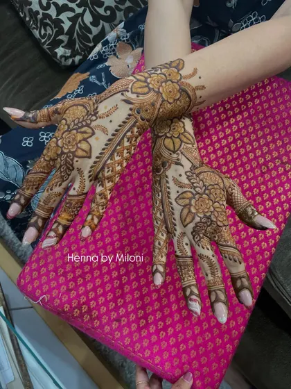 Another angle of the floral Arabic design, showing how the two hands create a complementary, flowing pattern.