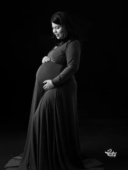 A classic black and white low-key portrait. The single light source sculpts the subject, creating a dramatic and timeless image that focuses on her expression and form.