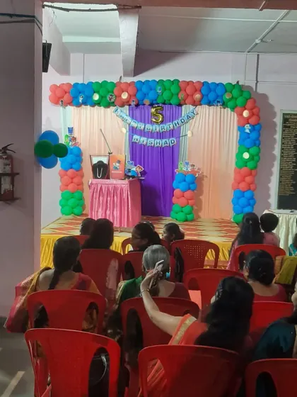 A 5th birthday party with a simple stage and a colorful balloon arch. Even a simple setup can be made special and festive.