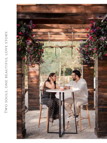 A candid pre-wedding moment of the couple sharing a conversation at an outdoor cafe setup, creating a relaxed and natural feel.