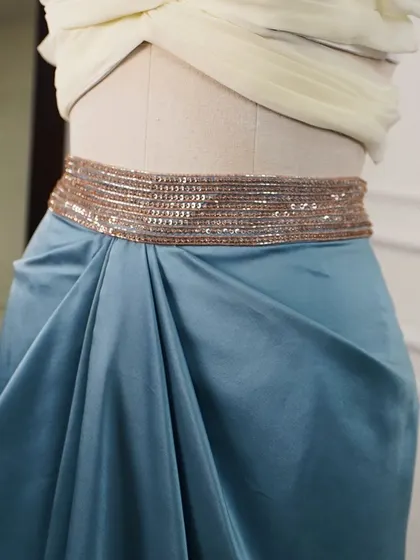The focus here is on the shimmering, hand-beaded belt and the soft gathers of the draped satin skirt, showcasing my attention to detail.