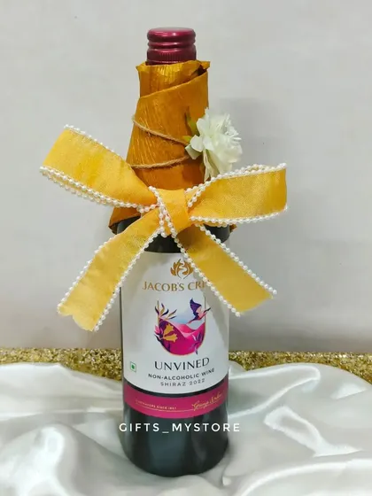 A beautifully wrapped bottle of non-alcoholic wine, adding a celebratory touch to the wedding hamper.