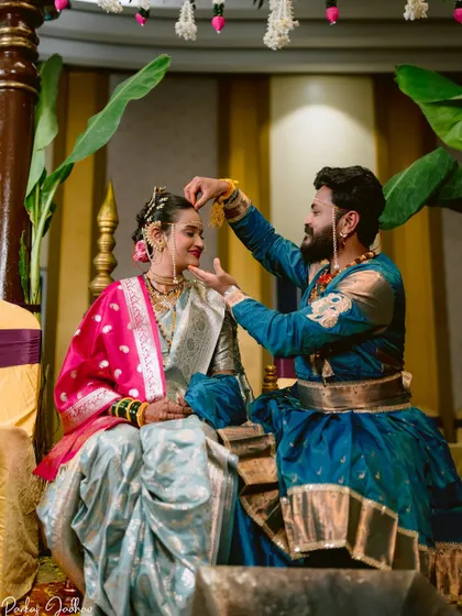 A moment from a traditional themed wedding, with the couple in historical Maratha attire.