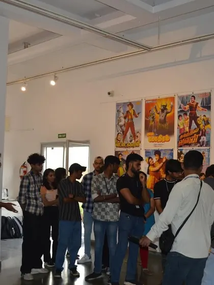 The student group listening to a guide explain the significance of the collected cinema memorabilia.