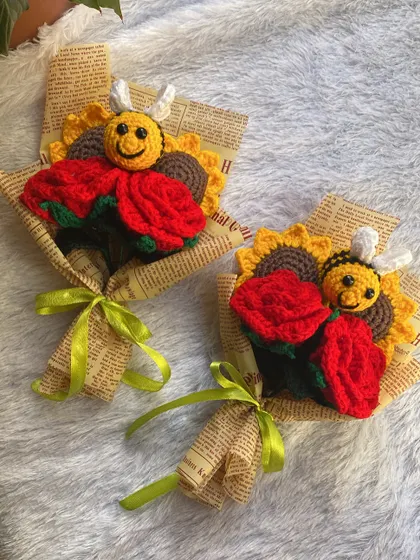 A pair of cheerful mini-bouquets. Each one features a bright red rose, a sunflower, and a happy little bee, making it a perfect small gift to brighten someone's day.
