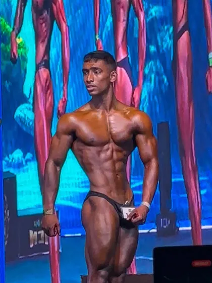 A full-body shot on the ICN stage. His balanced proportions, tight waist, and confident stage presence are exactly what we train for.