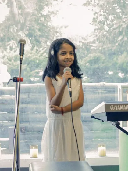 A young vocalist takes the stage at a student recital. From the practice room to the spotlight, we celebrate every step of their journey.