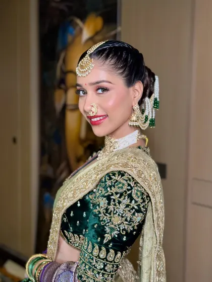 A confident and happy portrait. The bride's smile shines as she shows off her complete Peshvai look, from the intricate jewelry to the bold and beautiful makeup.