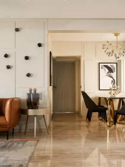 A wider view of the living and dining space, illustrating how I balanced the client's existing brown marble floor with a monochrome palette, pops of color, and statement rugs to create a fresh, modern aesthetic.