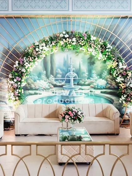 A beautiful photo-op area with a floral-draped arch framing a painted backdrop, creating a romantic and picturesque spot.