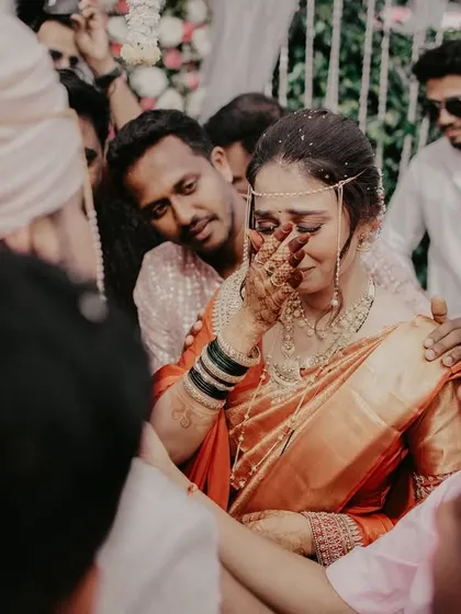 An emotional, candid shot of the bride during the 'bidaai' or farewell ceremony, surrounded by family.