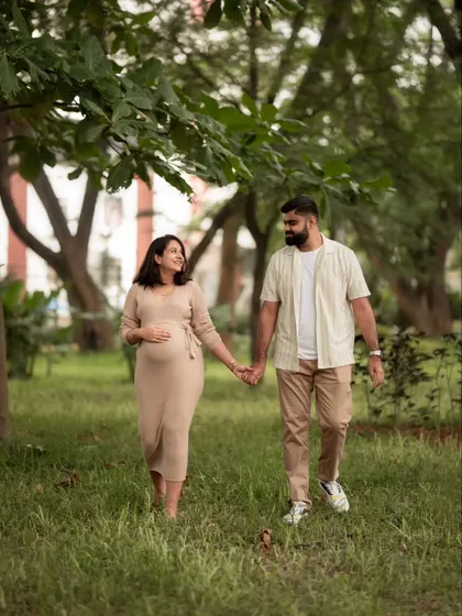 A casual stroll through the park. This couple's relaxed interaction and coordinated neutral outfits make for a beautiful and natural couples maternity photo.