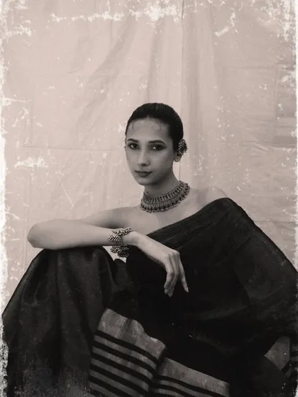 A vintage-inspired black and white portrait. The textured finish and classic pose give this image a timeless, old-world charm.