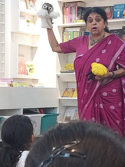 Another angle of a lively session, where puppets help bridge the gap between the teller and the listener. The wide eyes of the children in the front row tell their own story of captivation.