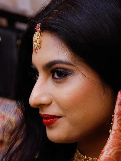 A close-up profile of a bride, showcasing her elegant makeup and the details of her henna.