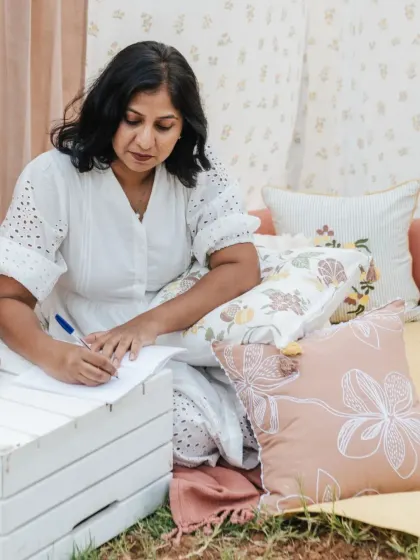 Our co-founder Abhinayah, enjoying a quiet moment surrounded by the soft textures and soothing hues of our 'Pause' collection cushions.