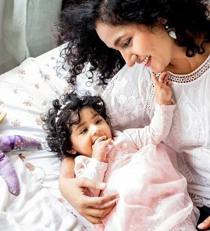 A mother and daughter enjoying a cuddle on the bed. Lifestyle sessions are perfect for capturing these authentic, loving interactions.