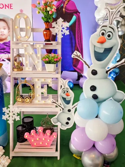 A light-up 'ONE' display shelf and an Olaf balloon sculpture are fun addition's to the Frozen theme.