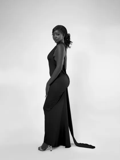 A full-length side profile. The long train of the dress adds a beautiful line to the composition.