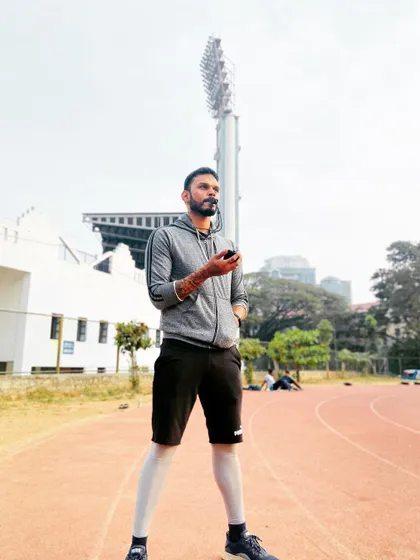 On the track with a stopwatch, living the coaching lifestyle. High performance is not just a job, it's a commitment to a way of life.