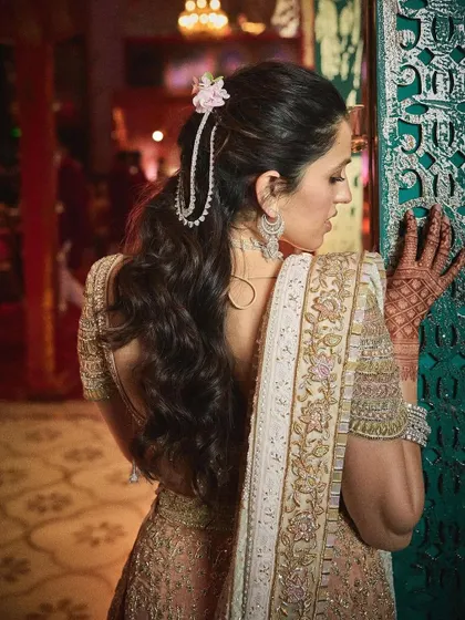 Stepping up in a gorgeous Abu Jani Sandeep Khosla lehenga. This look is all about intricate details, from the hair accessory to the mehndi on her hands.