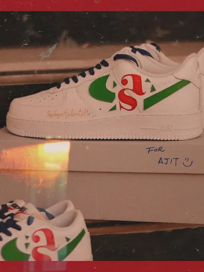 The two pairs of custom sneakers for the couple, side-by-side. One pair of Air Force 1s and one pair of Blazers, both featuring the same custom initial design.