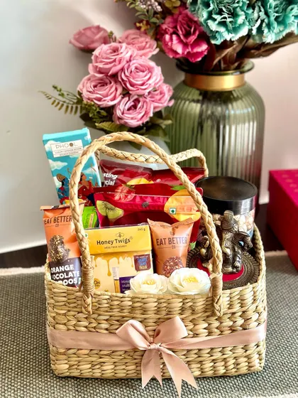 A healthy and wholesome Diwali basket, featuring a Ganesh idol, green tea, berry mix, roasted chips, and honey twigs.