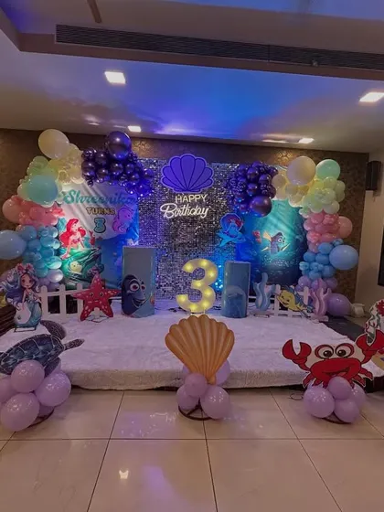 Dive into an underwater adventure! This enchanting Mermaid theme was for a 3rd birthday in Chembur. I used a shimmering sequin backdrop, character cutouts of Ariel and her friends, a light-up number '3', and balloon sculptures of crabs and octopuses to bring the ocean magic to life.