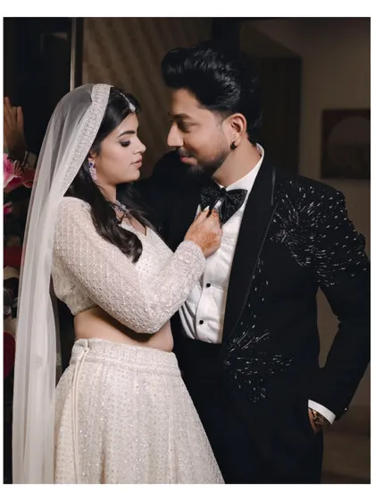 A playful yet intimate moment as the bride adjusts the groom's bow tie. These small, unscripted interactions often make for the most memorable photographs.