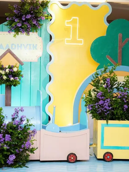 A wider view of the pastel train and backdrop, showing how the different elements come together to create a beautiful and imaginative scene for Aadhvik's first birthday.
