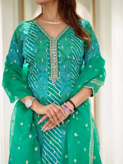 Grace stitched in green. A close-up of the beautiful bandhani print and embellished neckline on this stunning Anarkali.