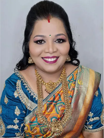 Chitra looking radiant and happy, all ready for the celebration. Her bold lip and smokey eyes are perfect for a festive party look.