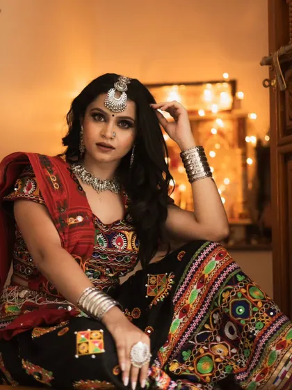 A classic Navratri look with a focus on dramatic eyes and traditional silver jewelry. The bindi and borla (maang tikka) complete this festive and authentic look.