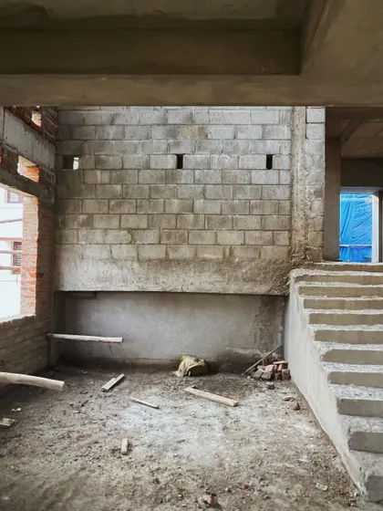 A similar view of the raw interior, highlighting the textures of the concrete and blockwork before finishing is applied.