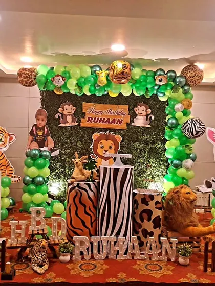 A classic jungle animal theme for Ruhaan's first birthday. This setup includes a greenery backdrop, cute animal cutouts like a giraffe and tiger, and balloon columns to bring the friendly jungle to life.