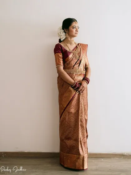 A full-length portrait of bride Aditi in her magnificent Kanjivaram saree, a picture of South Indian bridal elegance.