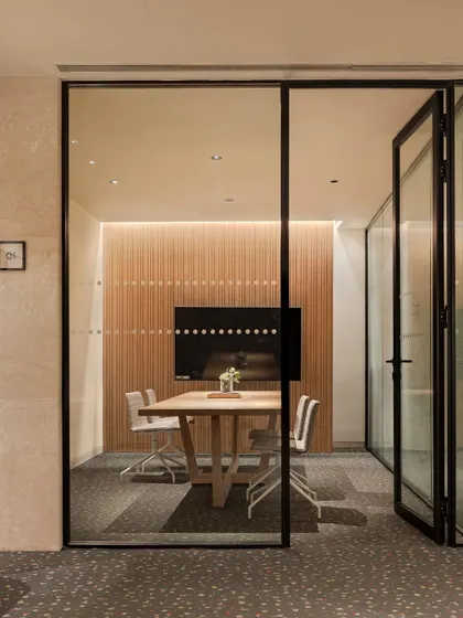 The business centre at the Elevate Clubhouse in Gurugram offers a professional environment within the community. This glass-walled meeting room provides acoustic privacy while maintaining a visual connection to the rest of the space, embodying modern, flexible work-life integration.