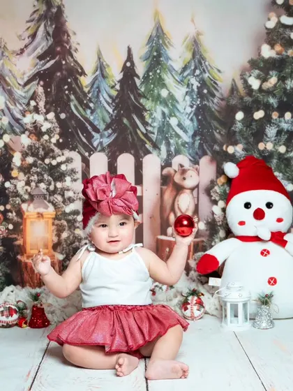 A cute baby girl in a festive red and white outfit from a past Christmas session. Our holiday themes are always a hit.