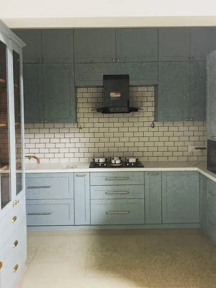 A wider view of the pastel blue kitchen, showing how it integrates with the rest of the home's aesthetic.