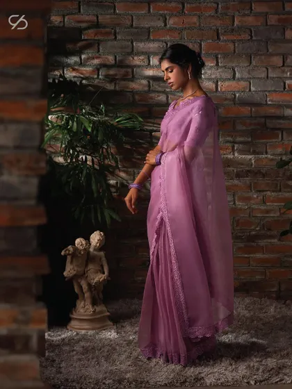 This lavender organza saree, with its delicate lace border, creates an aura of ethereal grace, perfect for an elegant evening affair.