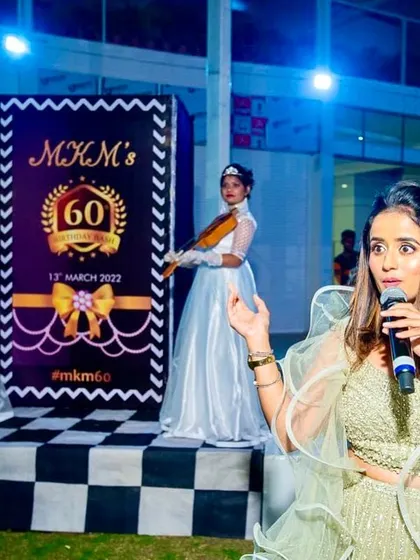 A shot of me hosting on stage, with the event's custom branding and the violinists in the background. Every detail is planned to reinforce the theme.