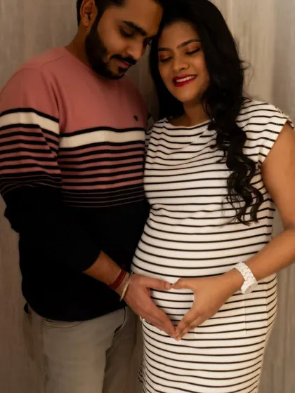 A color version of a classic pose. The couple's hands forming a heart on the baby bump is a universally understood symbol of love.