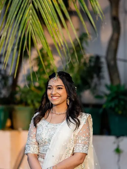 A beautiful portrait against a natural backdrop. The soft makeup and elegant lehenga create a look of timeless beauty.