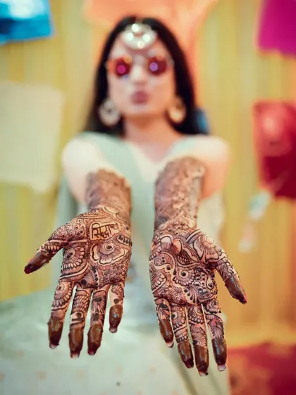 A beautiful shot focusing on the bride's hands, showcasing the intricate and artistic mehendi design.