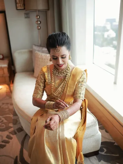 A quiet moment of reflection by the window. The natural light catches the subtle shimmer on her eyelids and the glow of her skin.