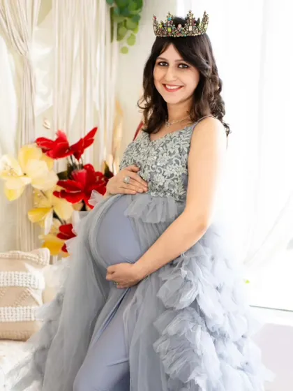 A happy and bright portrait of a mom-to-be in a silver and blue gown. This image highlights the detailed sequin work on the bodice and the soft tulle skirt.