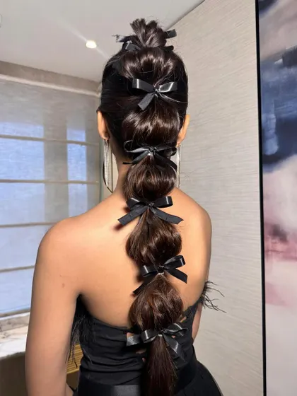 For a fun and fashion-forward look, I created this bubble braid and adorned each section with a delicate black bow. This is a great option for a cocktail party or bachelorette.