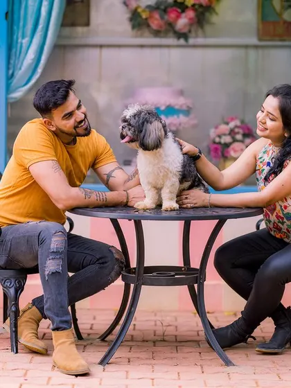 A sweet moment of a couple and their dog at a cafe table. This shot is full of love and personality, capturing a happy family moment.